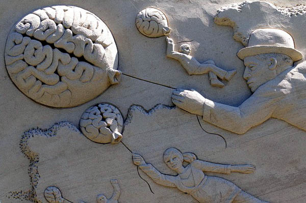 relief sculpture of people floating on brain balloons