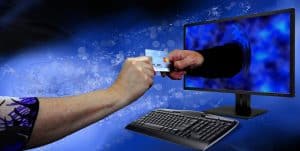 hand offering credit card to computer